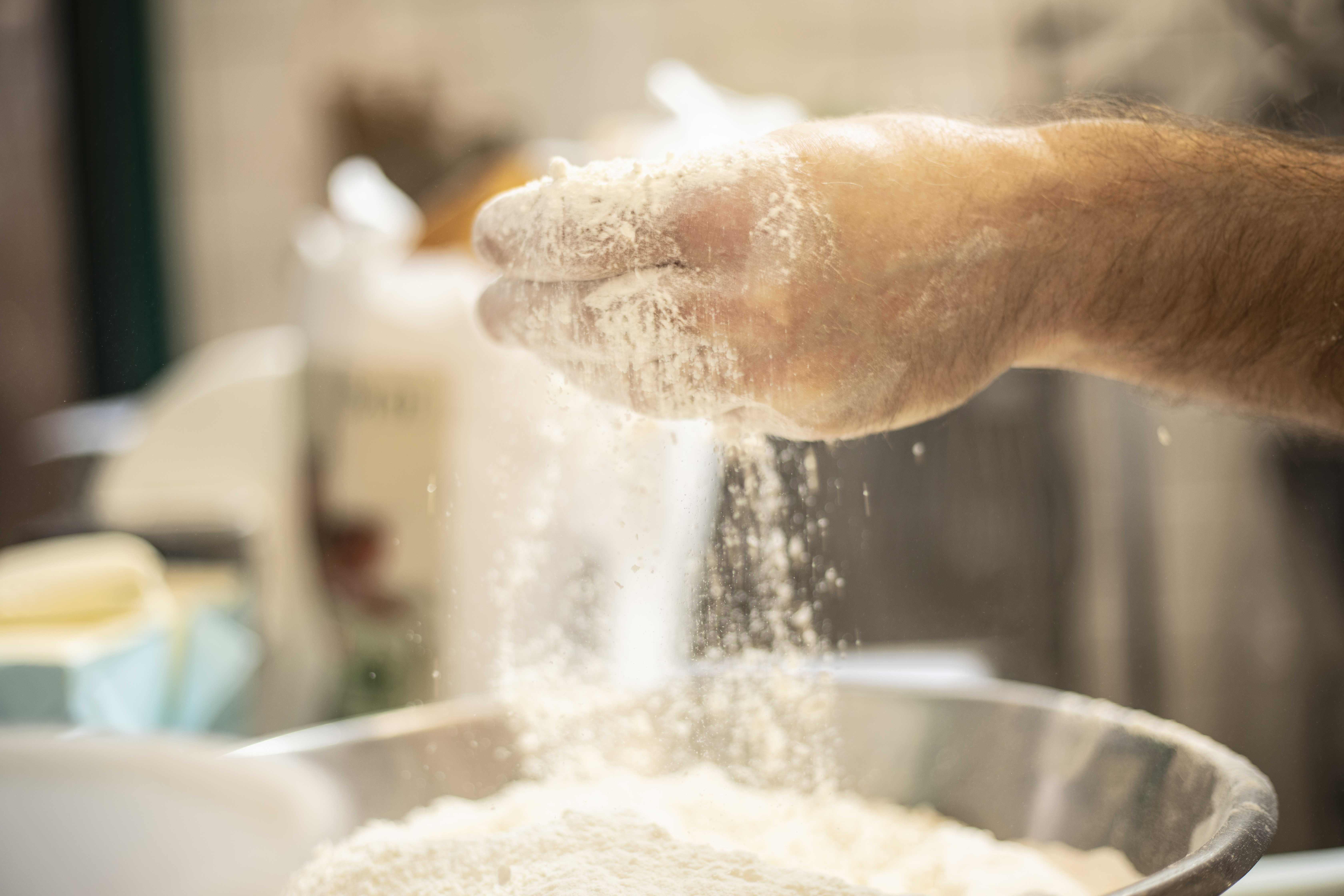 Hånd tilsætter mel