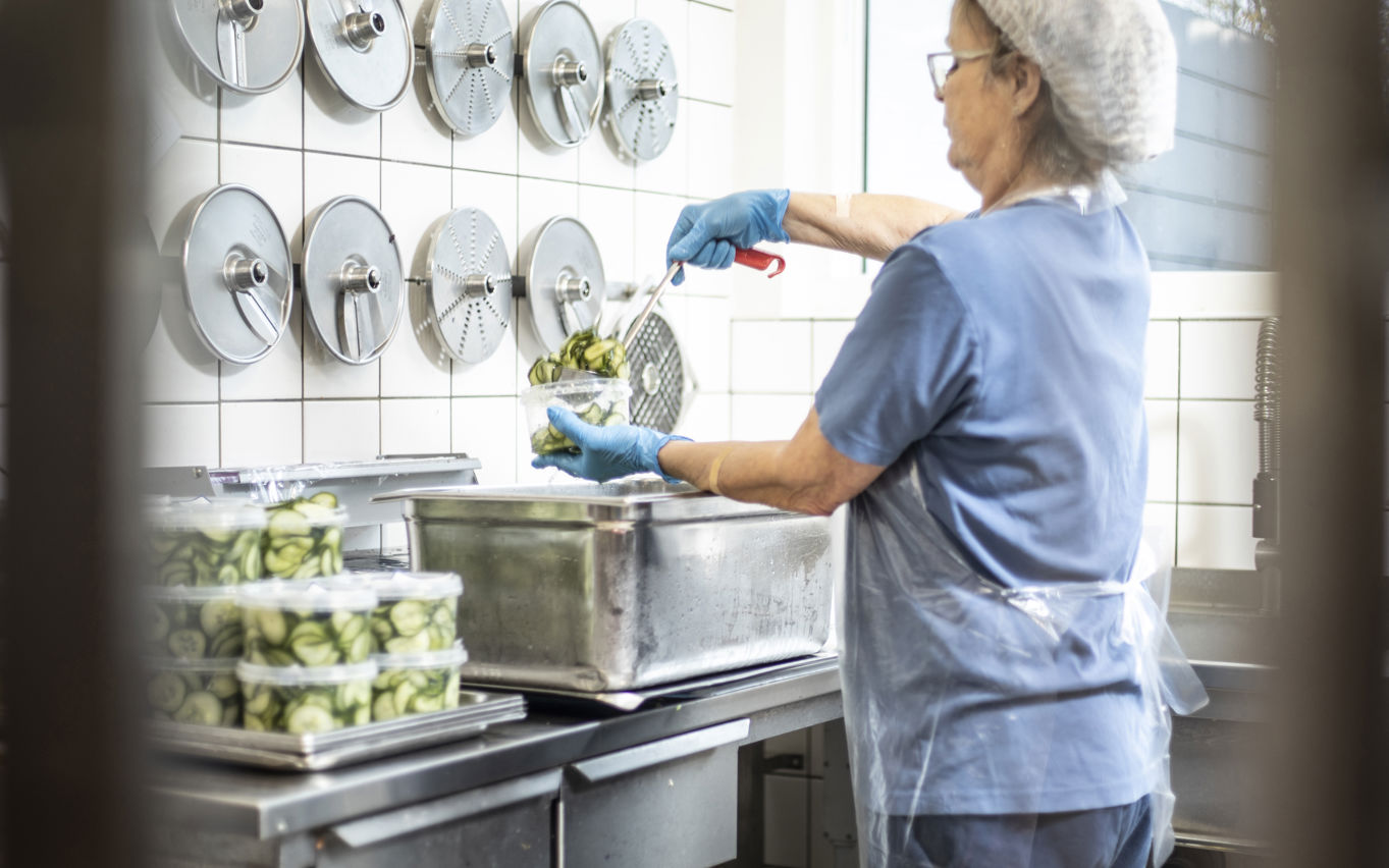 Medarbejder pakker hjemmelavet agurkesalat