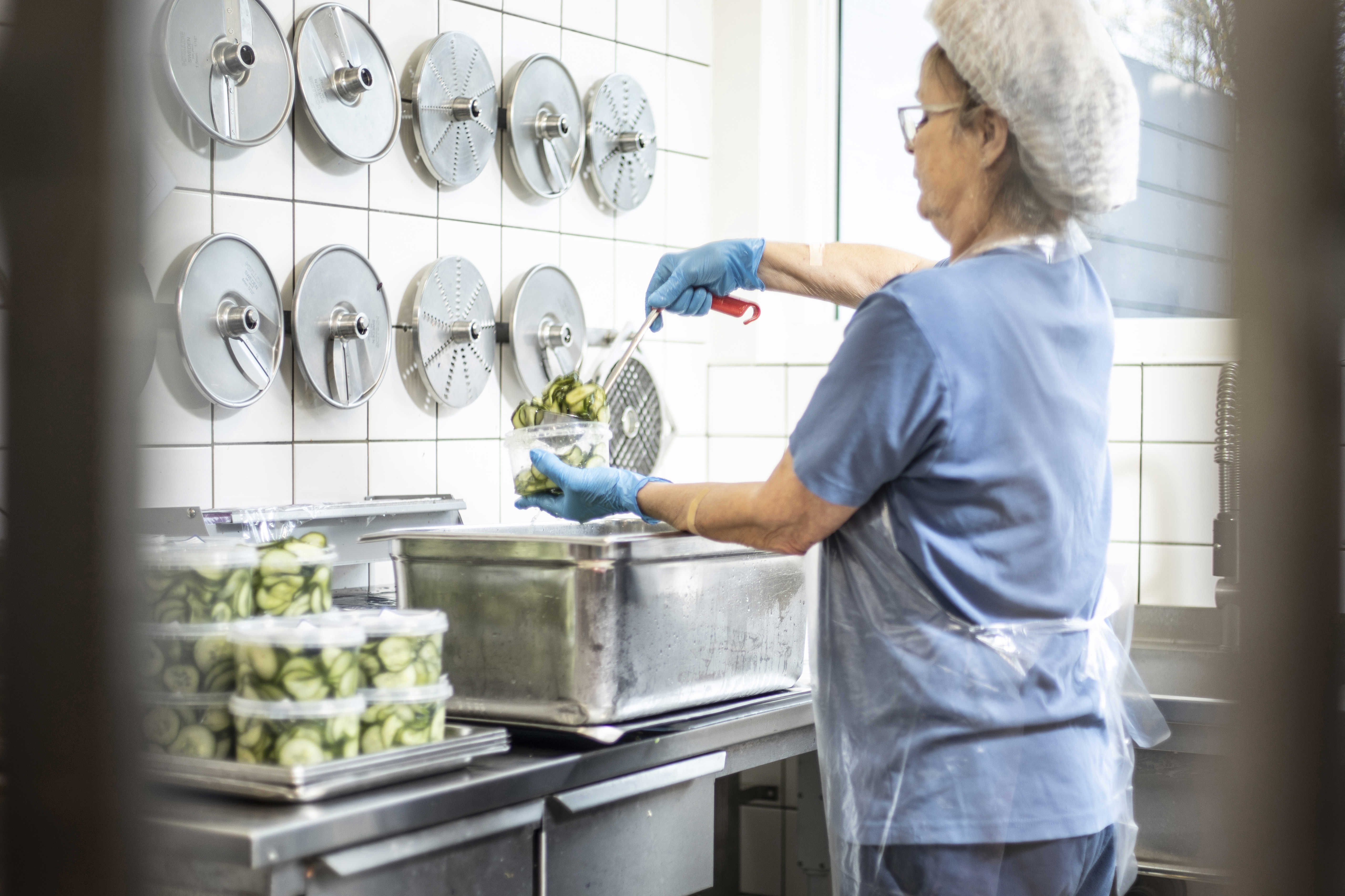 Medarbejder pakker hjemmelavet agurkesalat